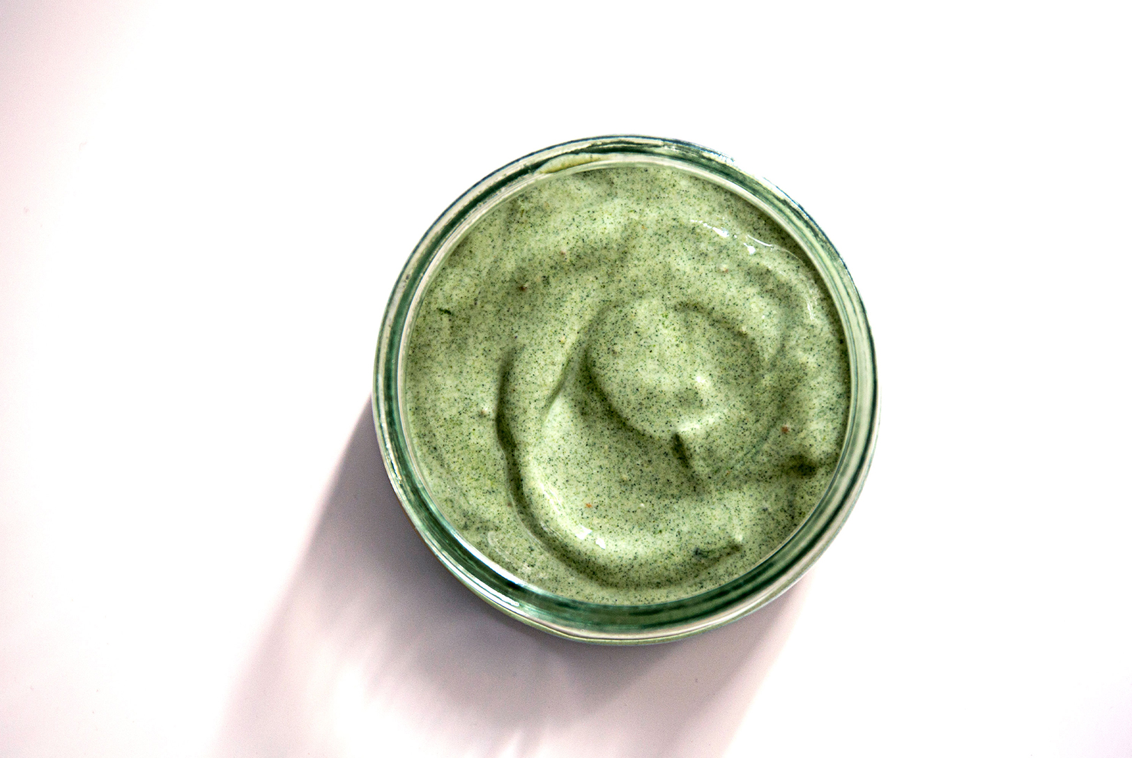 overhead shot of a green smoothie in a cup with a white background