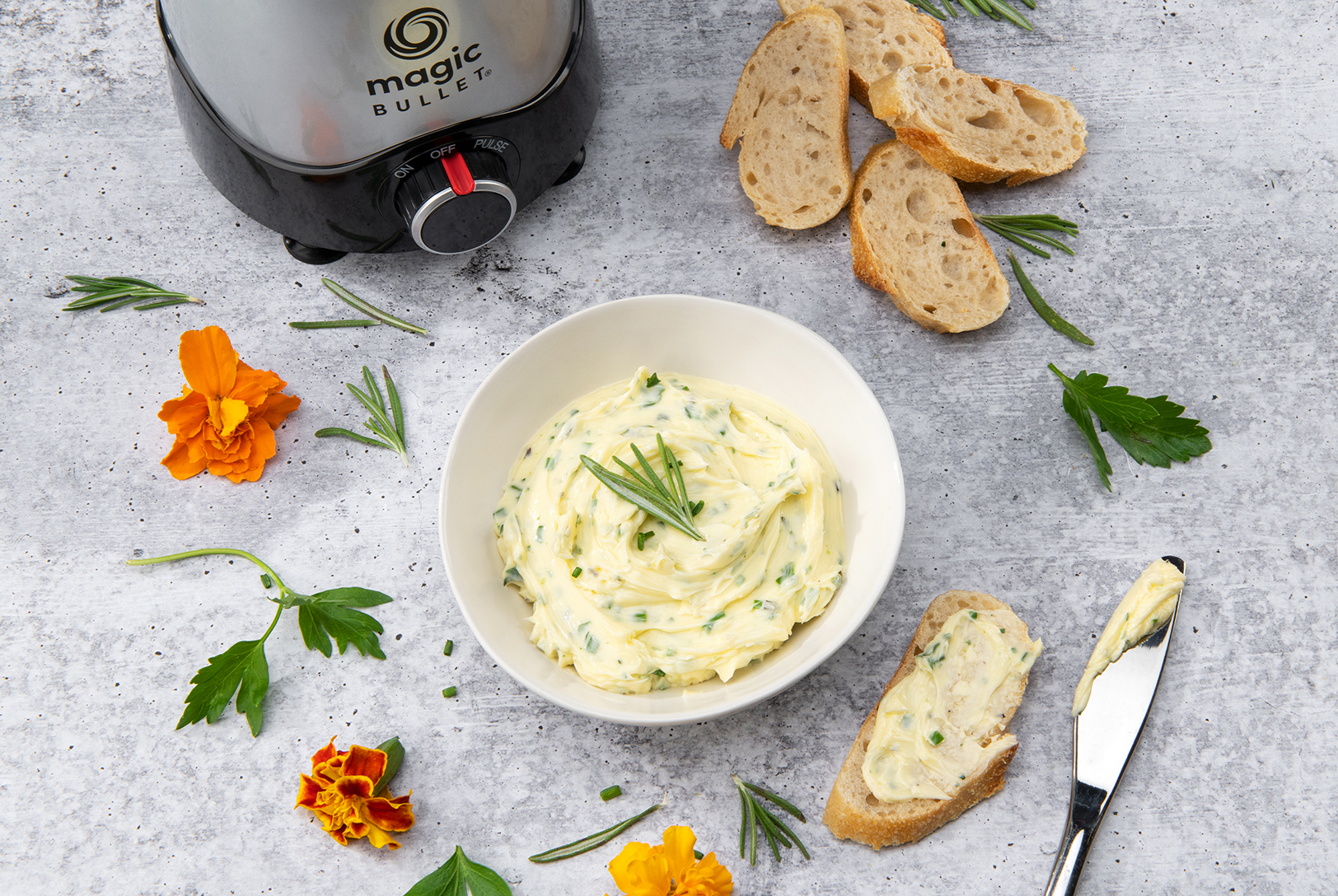 magic bullet kitchen express and bowl of garlic butter with bread slices 