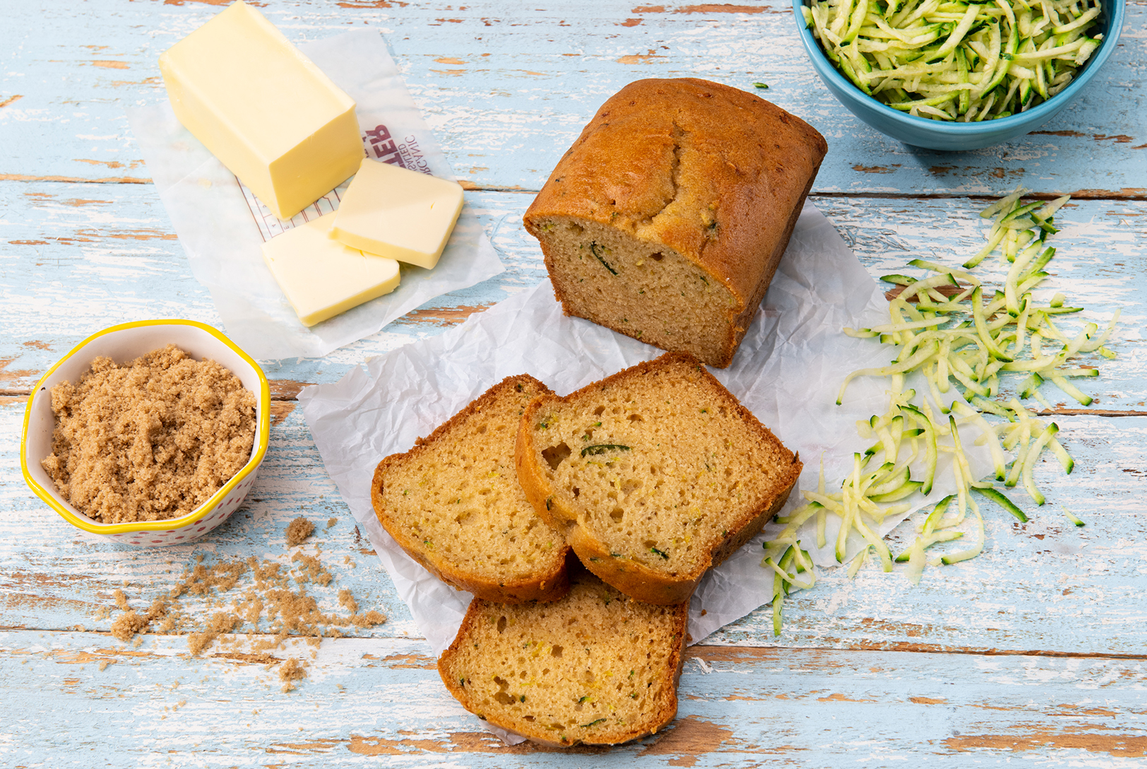 slices of spiced zucchini bread with butter, grated zucchini, and cinnamon sugar