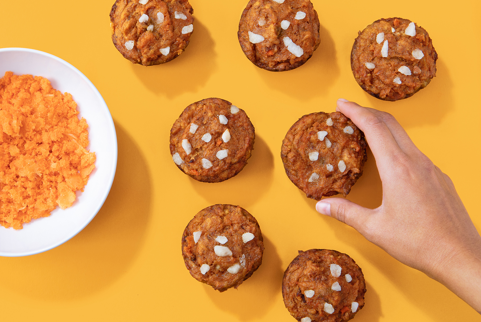 hand holding a pumpkin carrot muffin made with carrot juice pulp