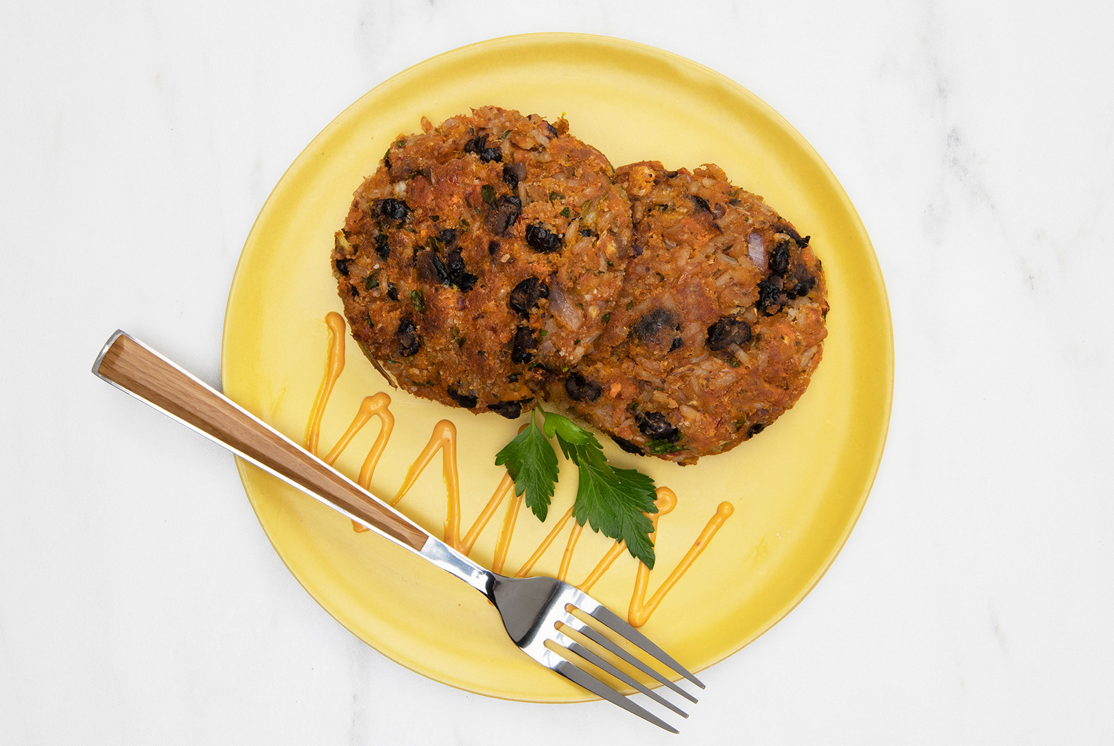 yellow plate of veggie patties with black beans