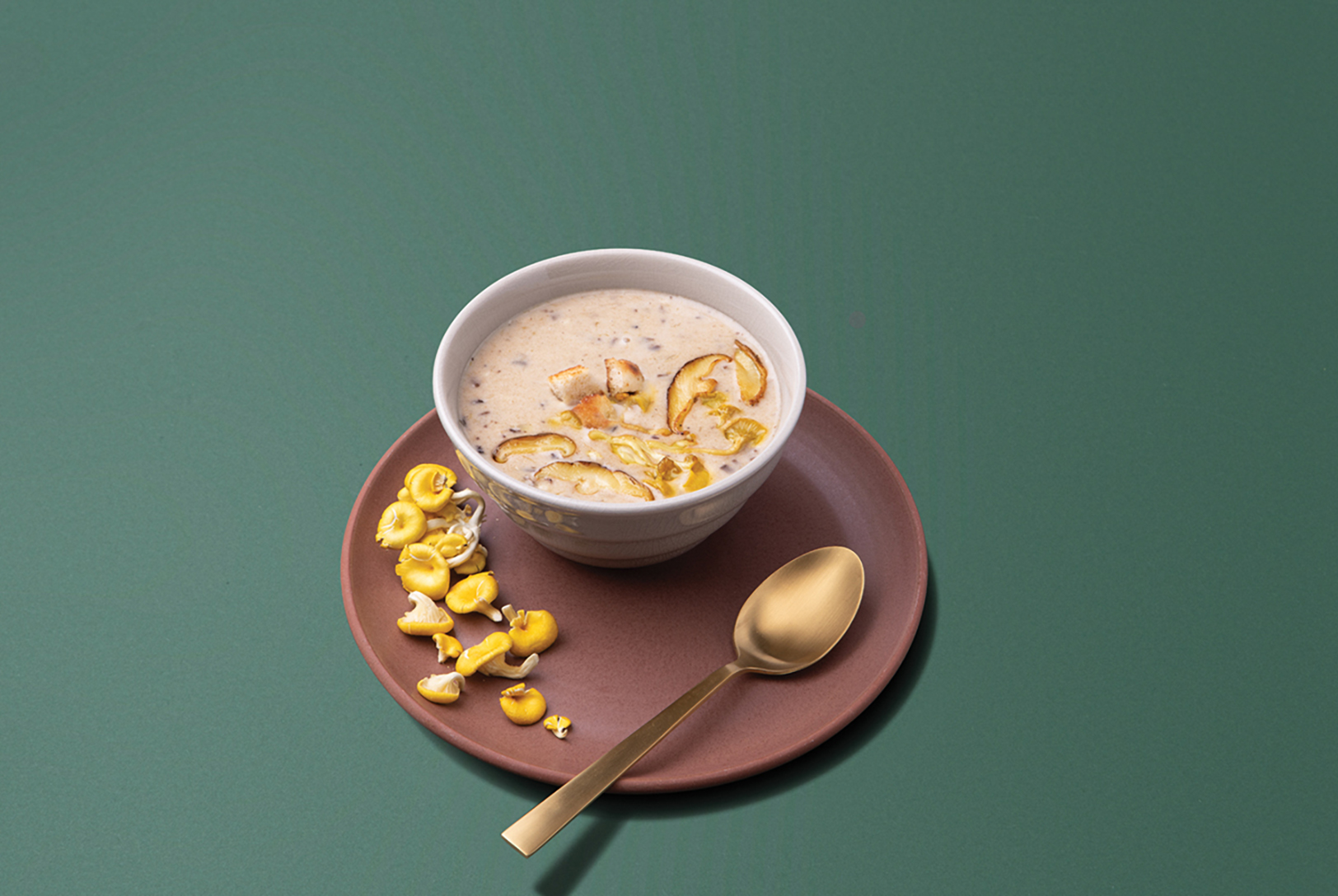 bowl of creamy mushroom soup with fresh mushrooms