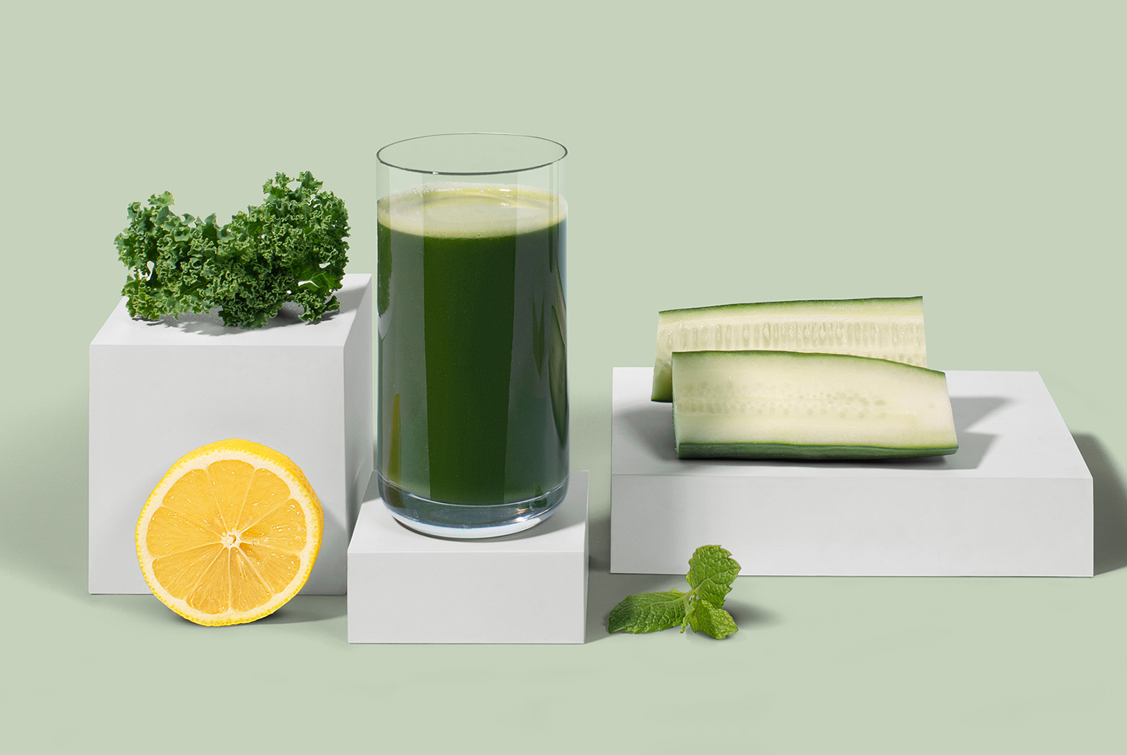 glass of green juice with kale, lemon, cucumber, and mint