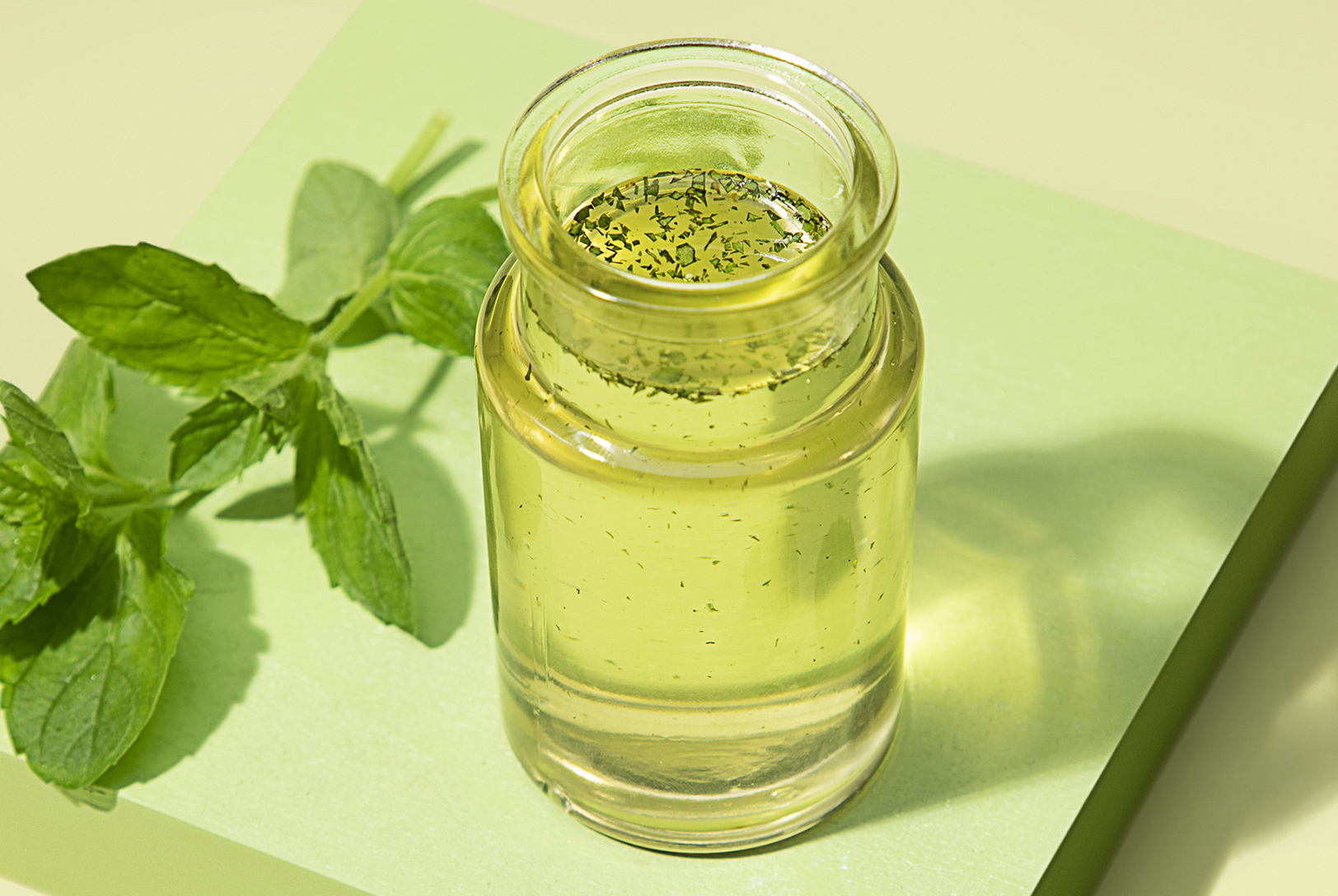 jar of homemade mint syrup with fresh mint