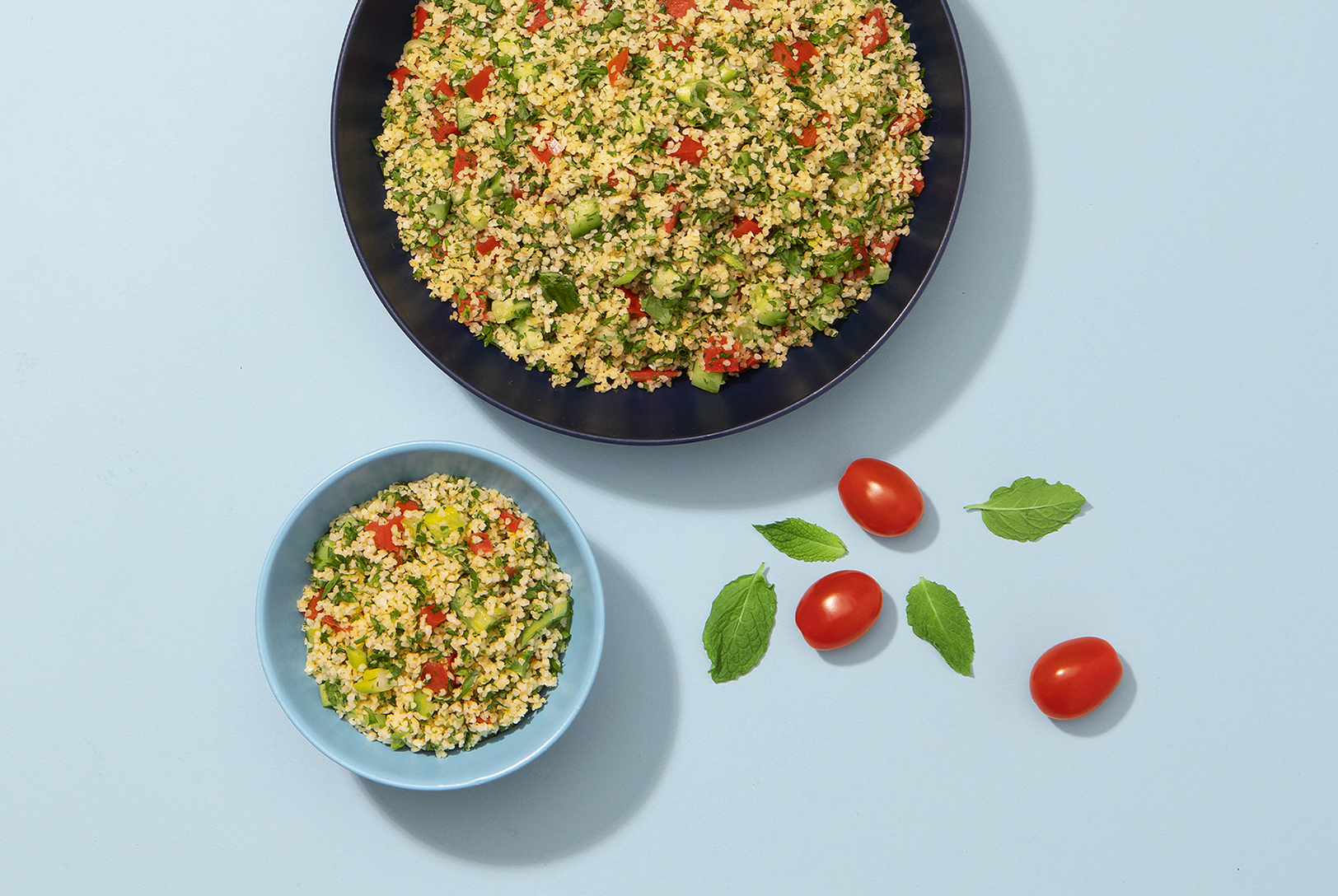 two bowls of tabbouleh with tomatoes and herbs