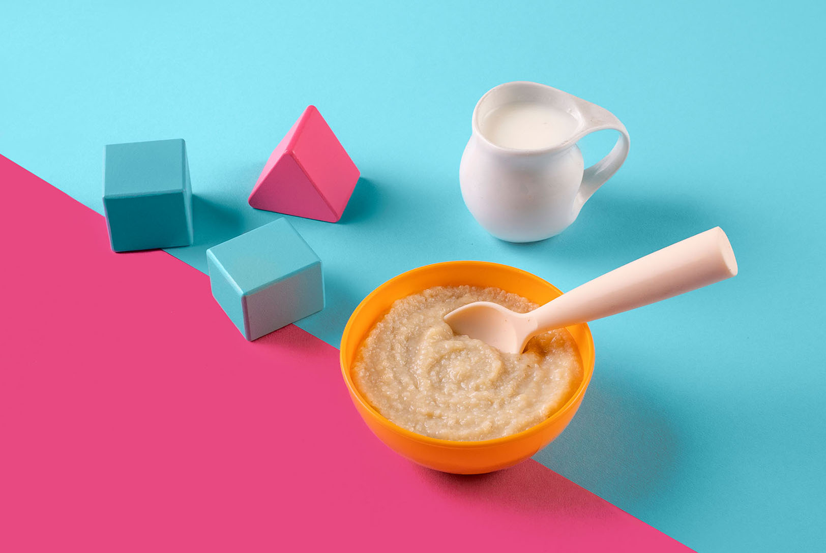Brown rice cereal in a bowl next to milk and blocks