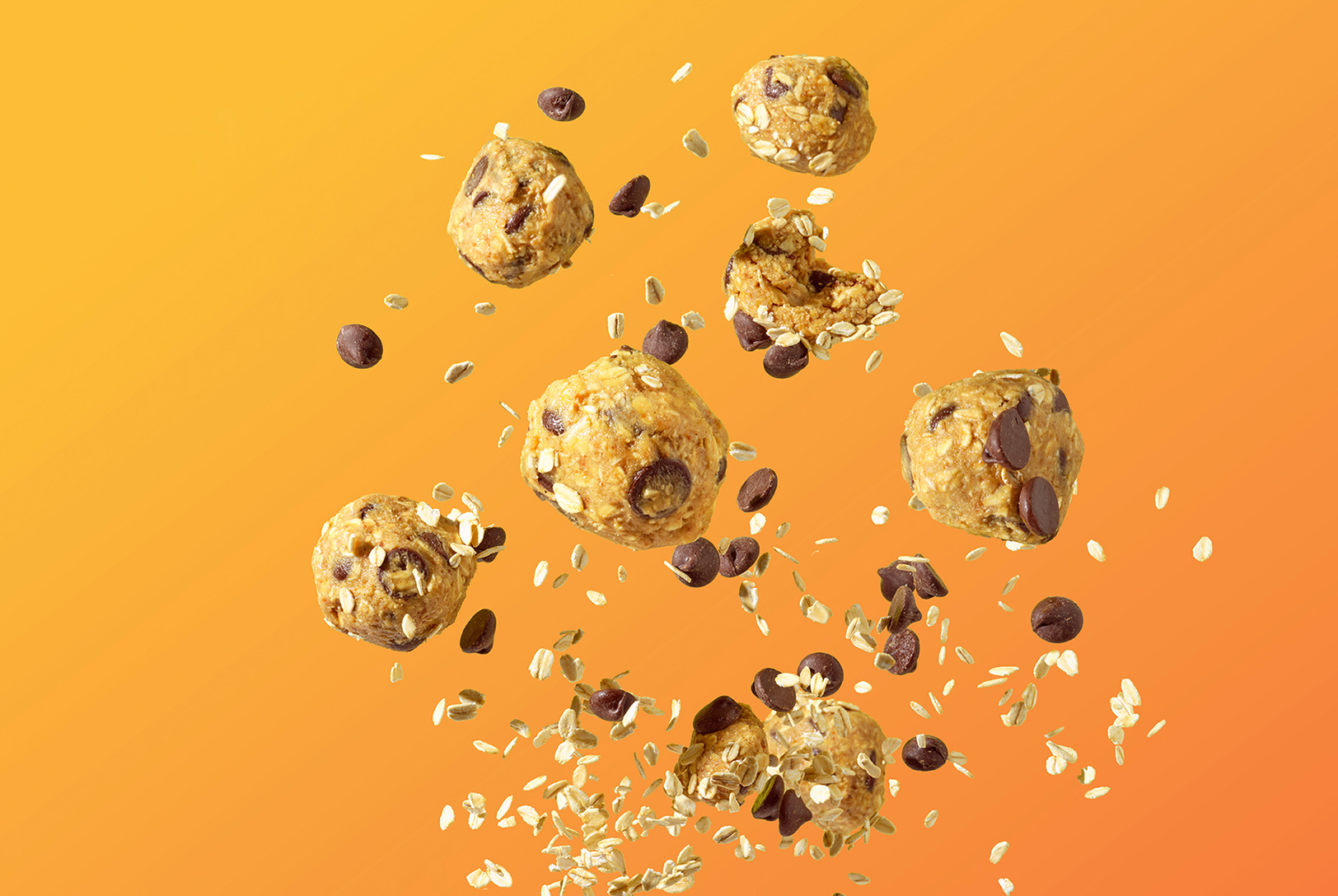 Oatmeal Chocolate Chip Cookie Bites with dry oats and chocolate chips floating against an orange background.